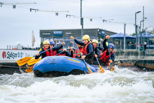 Wassersportler in einem großen Schlauchboot auf der Wildwasseranlage
