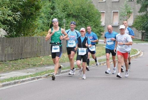 Ein Laufgruppe, die einem Zugläufer hinterherläuft