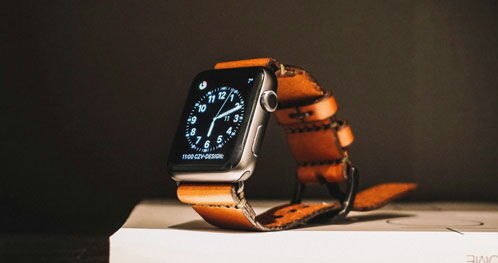 Smartwatch mit goldenem Armband vor schwarzem Hintergrund