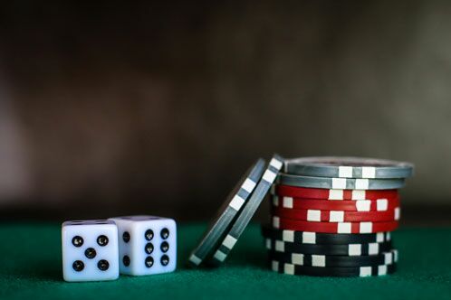 Zwei weiße Würfel und Spielchips vom Pokern