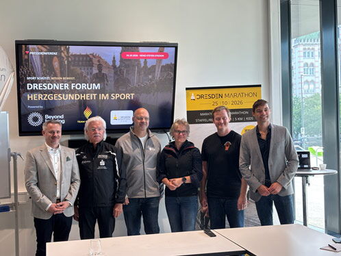 Sechs Personen vor einem Bildschirm mit Marathon Motiv