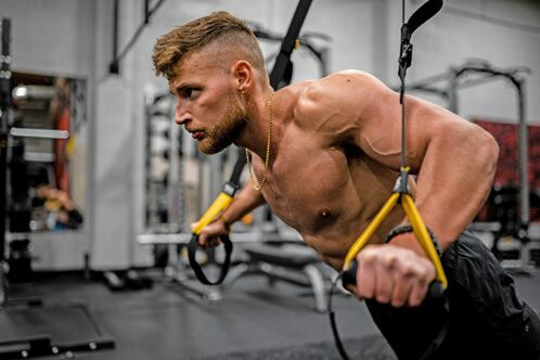 Muskulöser Mann trainiert mit dem aeroSling-Trainer