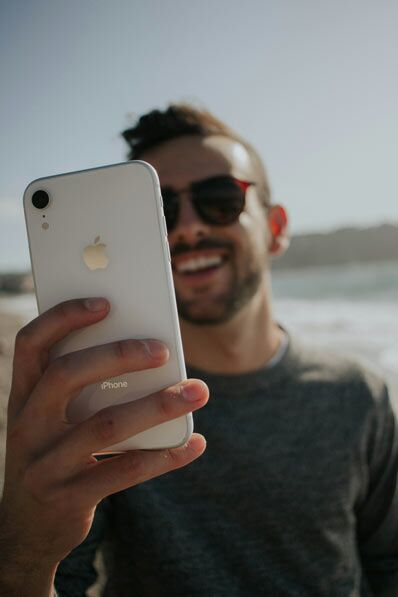 Mann der ein Smartphone vor sich hält