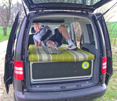 Mann liegt auf Kapok-Matratze in einem VW Caddy