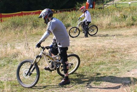 Downhillfahrer mit Helm auf einer Skipiste im Sommer