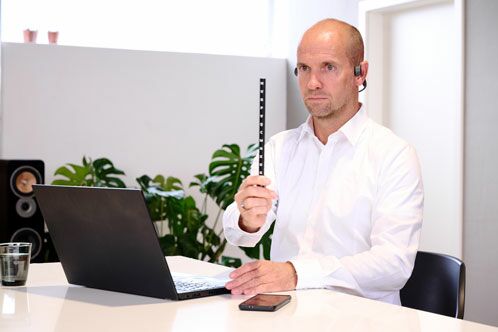 Mann mit weißem Hemd beim Augentraining mit einem Stab