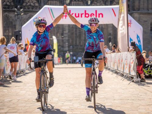 Zwei Radfahrer in blauen Trikots beim Zieleinlauf