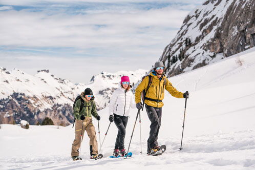 Skiwanderer auf einer Piste, im Hintergrund ein großer Berg