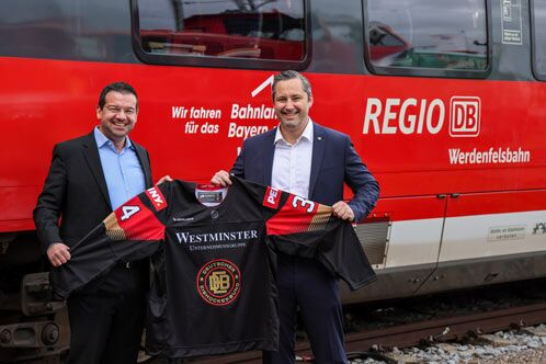 Zwei Männer vor einer roten Regionalbahn
