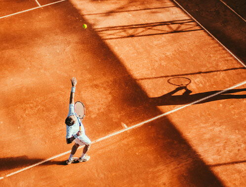 Tennisspieler auf dem Sandplatz beim Aufschlag