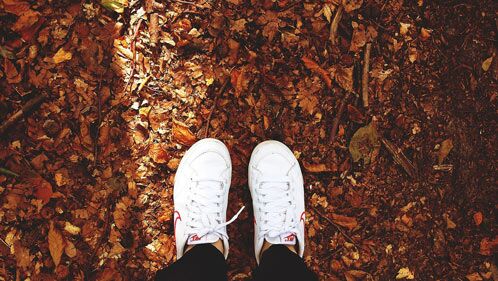 Weiße Schuhe im Herbstlaub