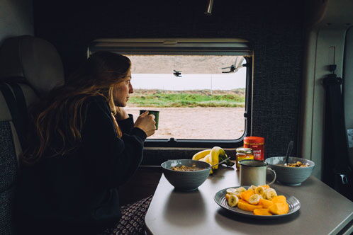 Frau beim Essen in einem Wohnmobil