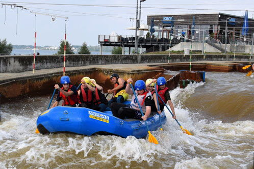Junge Sportler in einem Schlauchboot beim Rafting