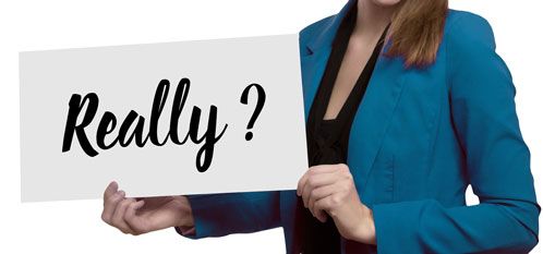 Frau hat Schild mit Aufschrift "Really?" in der Hand