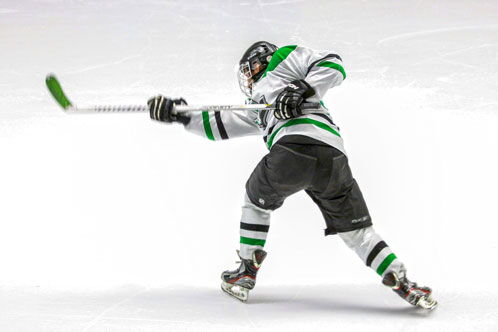 Eishockeyspieler beim Schlagschuss auf dem Eis