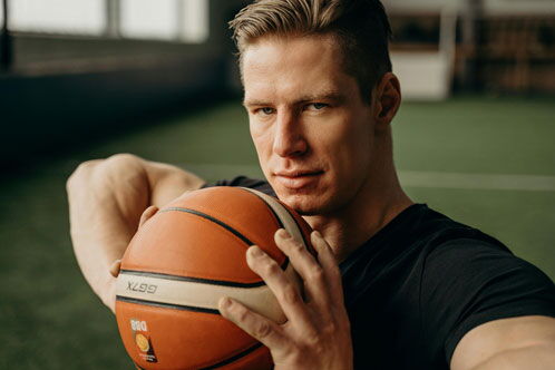 Sportlicher Mann mit einem Basketball in der Hand