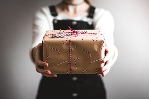 Frau, die ein Paket als Geschenk in der Hand hält