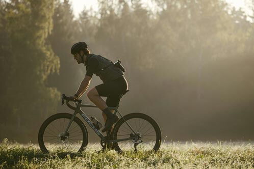 Radfahrer bei Morgennebel im Wald