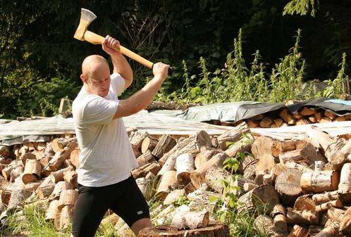 Mann hackt Holz mit einer Axt