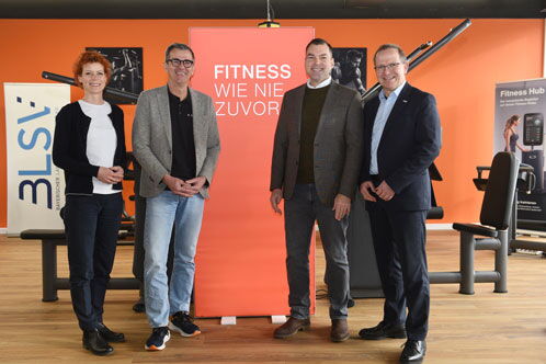 Vier Personen vor einer Plakatwand