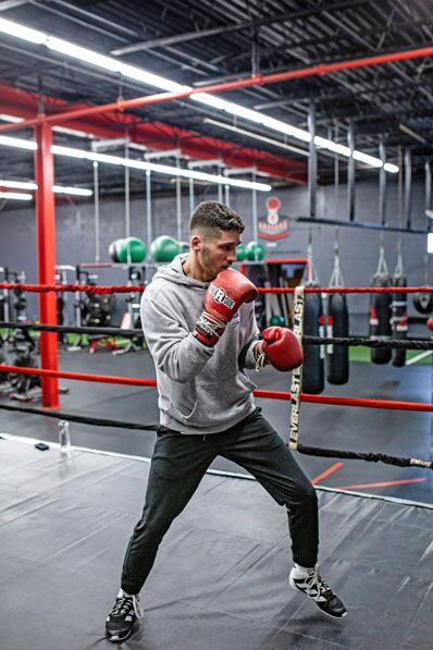 Mann mit schwarzen Leggins und grauem Sweatshirt im Boxring