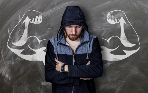Mann mit Kapuzenpulli vor einer Tafel