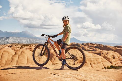 Kind auf einem Moutainbike, im Hintergrund trockende Sandwüste