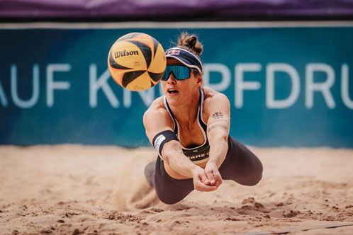 Beachvolleyballerin springt nach dem Ball