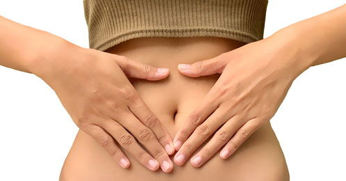 Bauch einer Frau mit verschränkten Händen davor