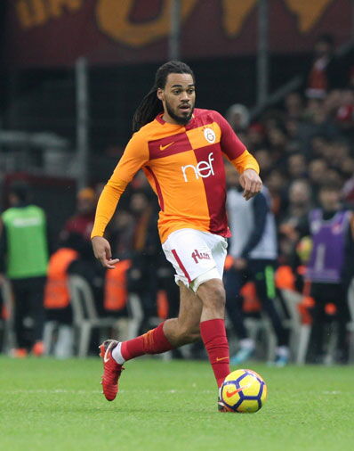 Fußballer mit orangem Trikot im Angriff