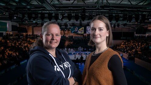 Zwei Frauen auf einer Tribüne in einer Sporthalle