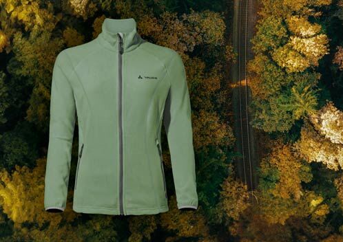 Grüner Jacke, im Hintergrund herbstlicher Wald