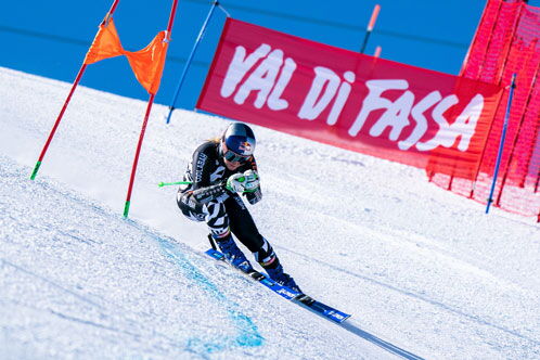 Skifahrerin bei der Abfahrt auf der Piste in Val di Fassa