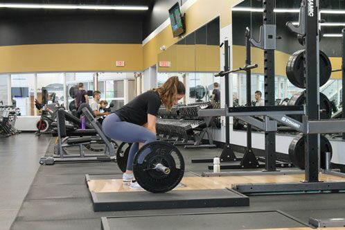 Frau im Fitnesscenter beim Kreuzheben mit der Langhantel
