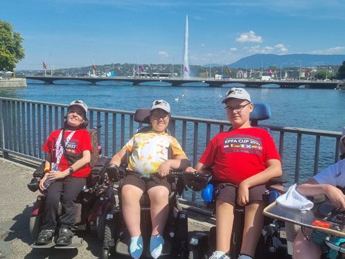 Drei Sportler im Rollstuhl vor einer Hafenpromenade