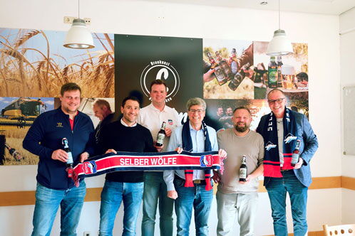 Sechs Personen aus dem Verein, die einen Fanschal halten