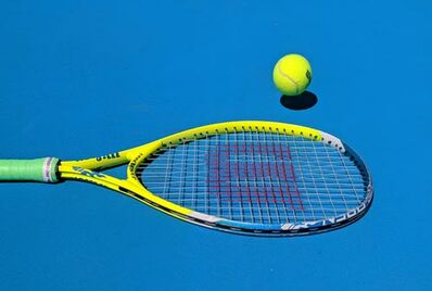 Gelber Tennisschläger auf blauem Spielfeld