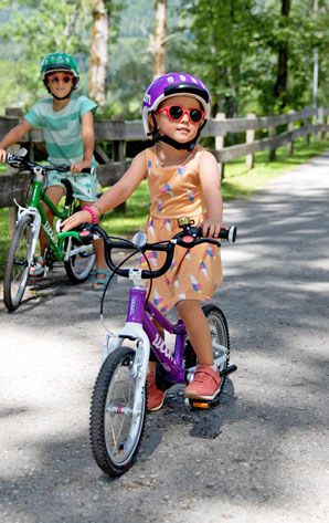 Kinder mit Sonnenbrillen auf ihren Fahrrädern