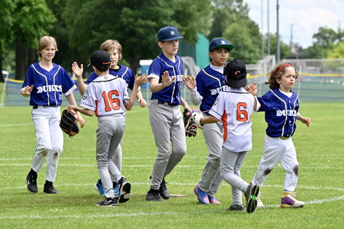 Gruppen von Kindern mit Baseballtrikots auf dem Rasen