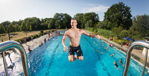Junger Mann springt vom 5-Meter-Turm ins Wasser