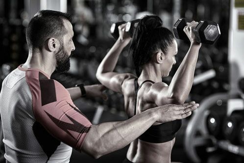 Personal Trainer trainiert mit seinem Schützling