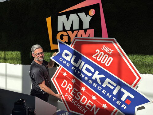 Heiko Poland hängt das neue Firmenschild auf