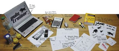 Schreibtisch mit Notebook und Entwurfsskizzen