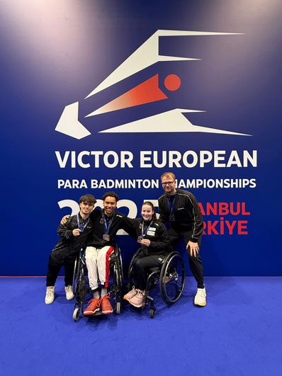 Das deutsche Para Badminton-Team vor einer blauen Wand