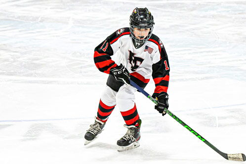 Jugendliche Eishockeyspielerin alleine auf dem Eis