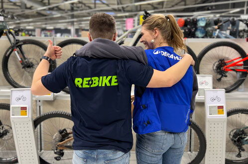 Zwei Mitarbeiter Decathlon und Rebike mit dem Rücken zum Betrachter