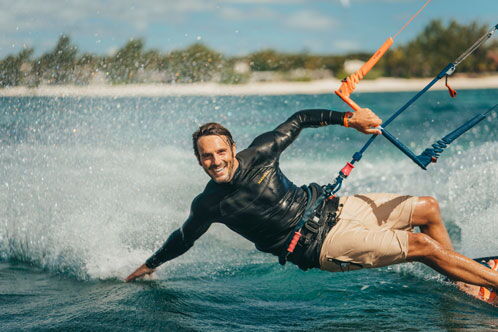Kitesurfer auf dem Wasser, der sich stark nach links lehnt