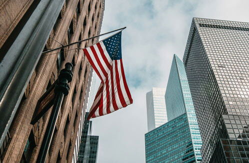 Wolkenkratzer und amerikanische Flagge in einer Innenstadt in der USA