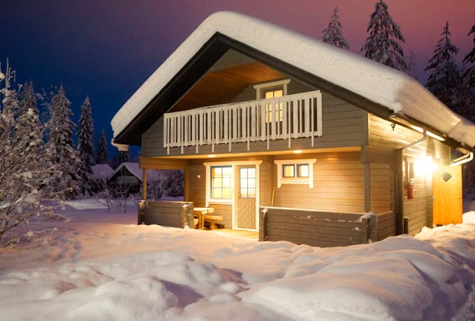 Erleuchtete Hütte in in finnischer Winterlandschaft